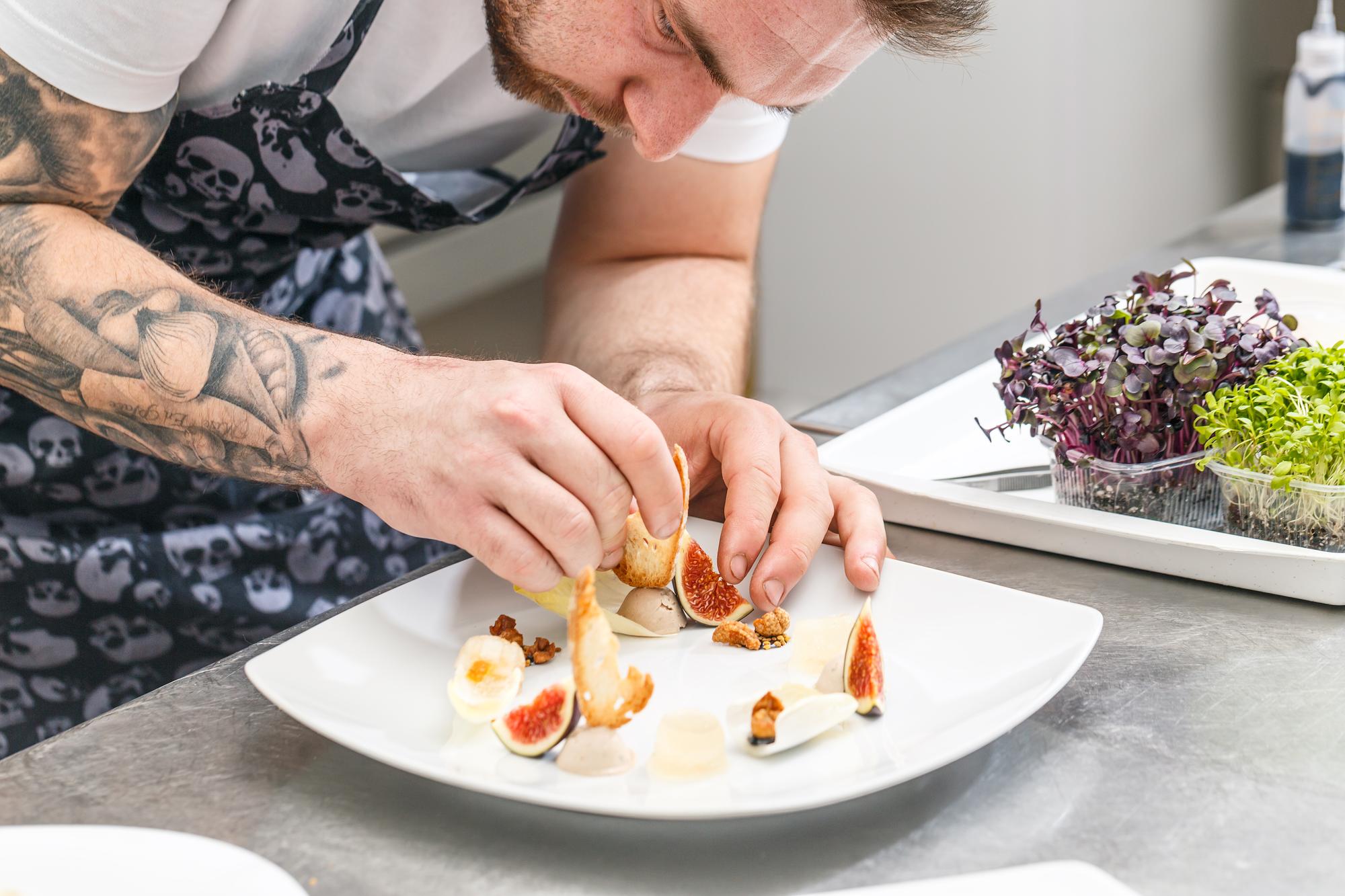 Instructor demonstrating plating technique in modern kitchen